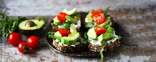 Healthy food. Avocado toasts with arugula and cherry tomatoes. Diet concept.