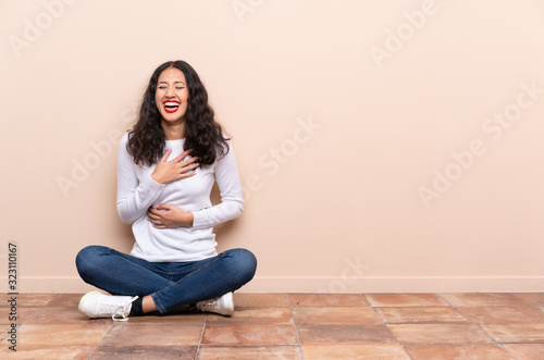 Young woman sitting on the floor smiling a lot