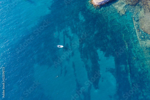 Fototapeta Naklejka Na Ścianę i Meble -  top view of jacht in turquoise water in Gran Tarajal, Canary islands, Fuerteventura, Spain. Aerial drone view in october 2019