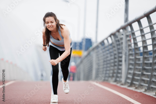 Fitness sport girl on intensive evening run, attractive runner jogging outdoors, female jogger in bright sportswear.