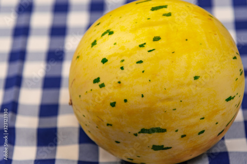 Whole melon fruits on a table on a blue and white tablecloth