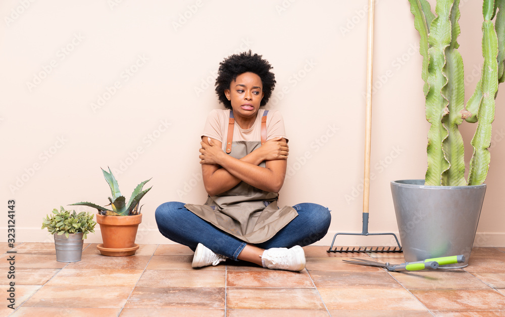 Gardener woman sitting on the floor freezing Gardener woman sitting on the floor freezing