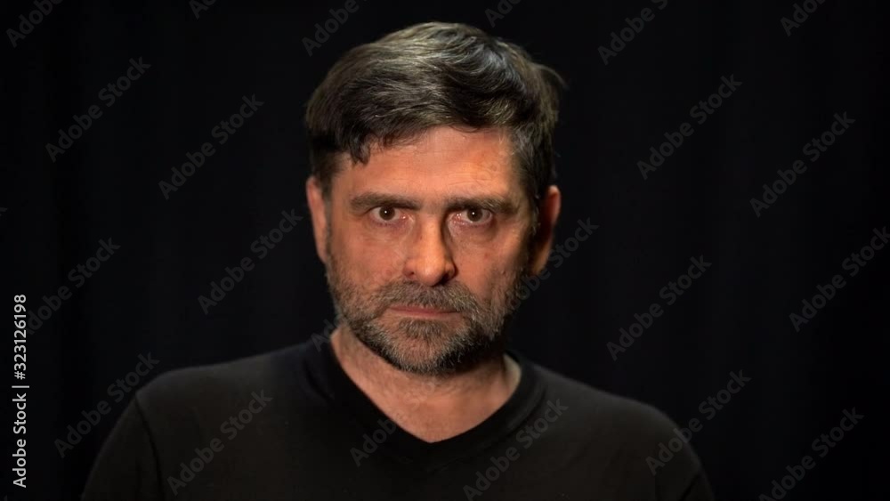 an older man looks into the camera with anger an older man looks into the camera with anger
