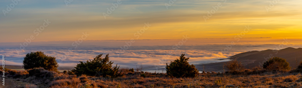 Obraz premium panoramic view of sunrise over the clouds on the mountain.