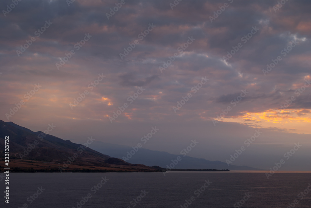 Lahaina, Maui, Hawaii, USA. - January 12 2012: Early morning light over ocean while approacing West side on dark ocean under spectacular cloudscape as if heaven is on fire. Shape of coastline hills.