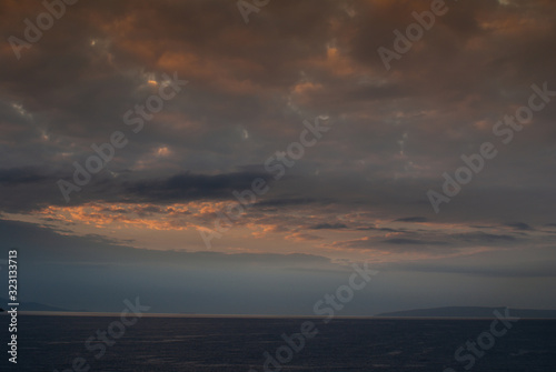 Lahaina, Maui, Hawaii, USA. - January 12 2012: Early morning light over ocean with fog near west side of the island, produces a dark cloudscape with parts as if set on fire. © Klodien