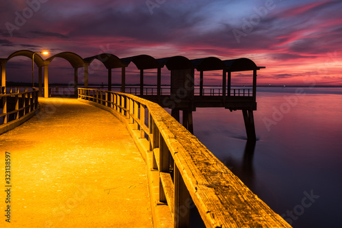 A beautiful ocean dramatic sunset and fishing pier at Jekyll Island in coastal Georgia, USA. photo