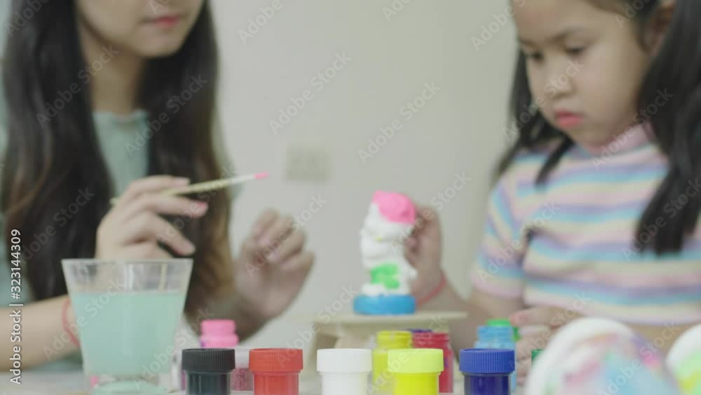 Sister and sister Have fun colouring plaster To decorate for the occasion of celebration Thanksgiving Day. Easter Day Concept. Sister and sister Have fun colouring plaster To decorate for the occasion of celebration Thanksgiving Day. Easter Day Concept.