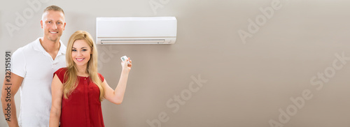 Couple With Remote Control Air Conditioner