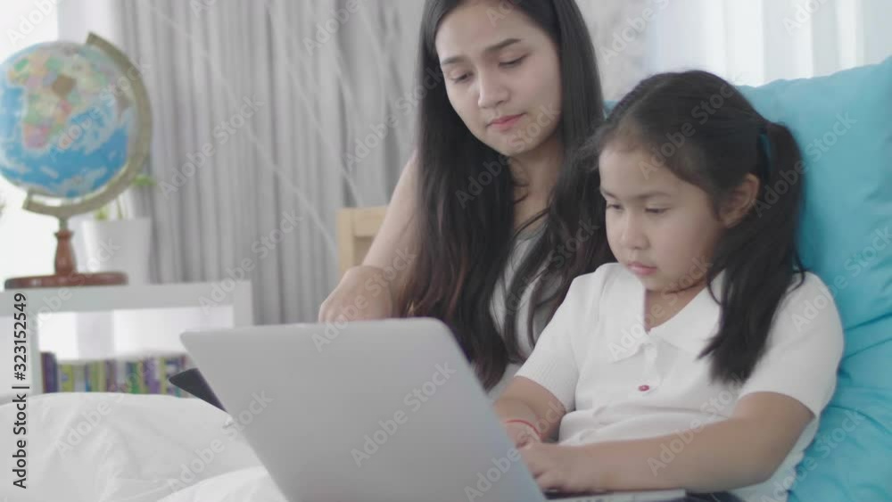 Asian girls and sisters are using laptops, computers and tablets to connect to the cyber world. The little girl rested at home using the internet. Asian girls and sisters are using laptops, computers and tablets to connect to the cyber world. The little girl rested at home using the internet.