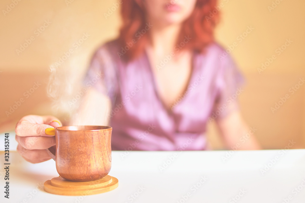 Amazing woman in a purple silk robe drinking coffee early in the morning in bed. Wooden cup of latte on the white tray. Breakfast concept Amazing woman in a purple silk robe drinking coffee early in the morning in bed. Wooden cup of latte on the white tray. Breakfast concept
