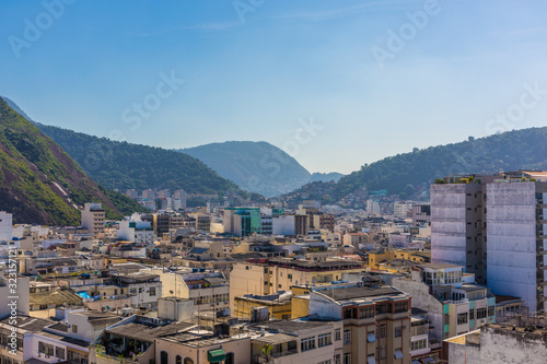 High aerial view looking across hotel and building rooftops among mountains during the day time within the Copacabana neighbourhood in the South Zone of Rio de Janeiro in Brazil, South America © Shawn