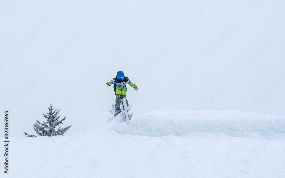 People are having fun in downhill skiing and snowboarding in the middle of snowfall 