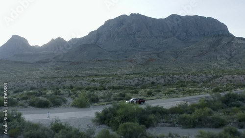 Aerial pan up of Big Bend Mountains and truck on road in West Texas. photo