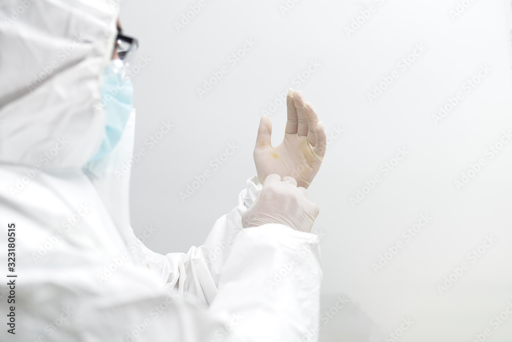 Fototapeta premium Asian male doctor wearing protective suits prepare before entering the quarantine area to develop a new vaccine against coronavirus. New testing for coronavirus emerges.