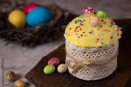 Festive cupcake for Easter with candy and decoration with colored eggs in different colors in the nest