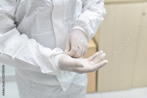 Asian male doctor wearing protective suits prepare before entering the quarantine area to develop a new vaccine against coronavirus. New testing for coronavirus emerges.