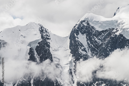 Photos Atmospheric minimalist alpine landscape with massive hanging glacier on snowy mountain peak
