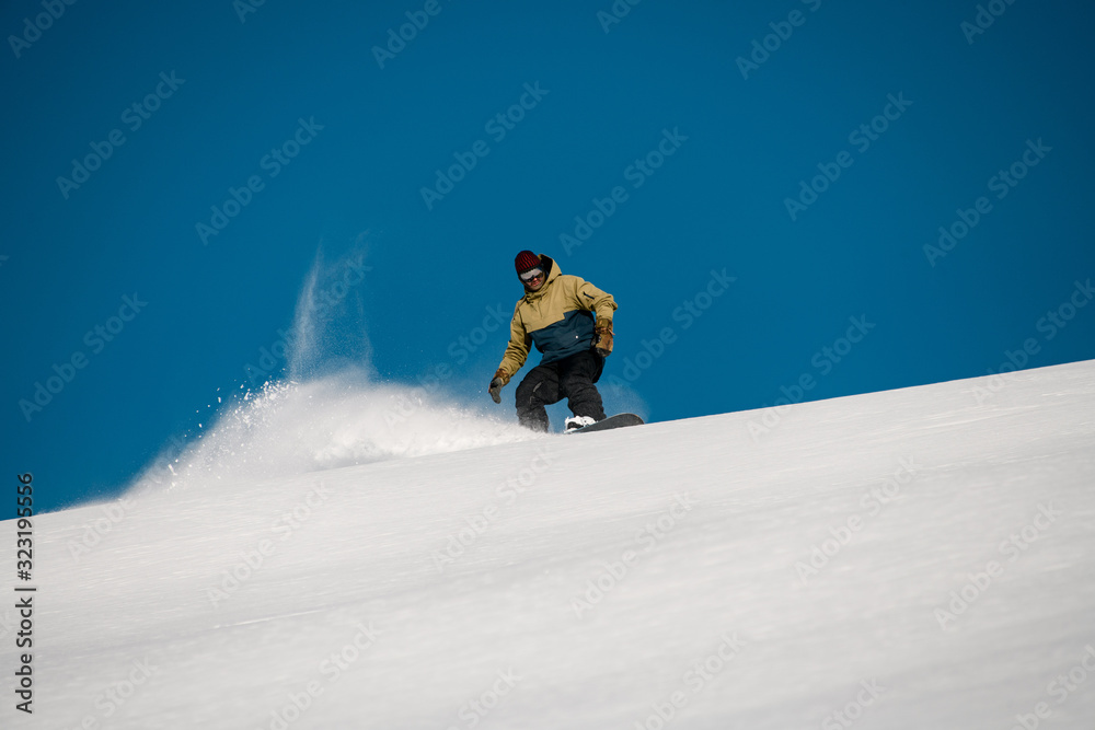 Male freerider slides down on the mountain side