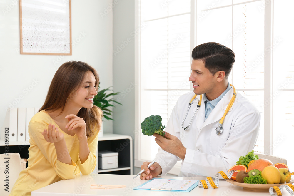 Nutritionist consulting patient at table in clinic Nutritionist consulting patient at table in clinic