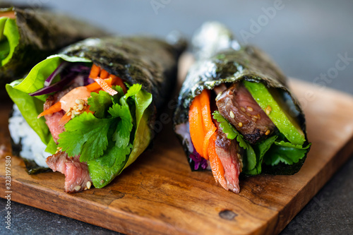 Beef temaki rolls with avocado, pickled carot and coriander photo