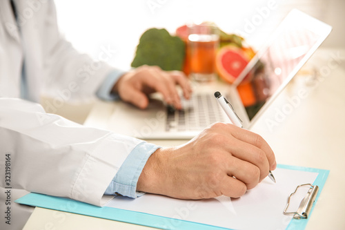 Nutritionist working at desk in office, closeup