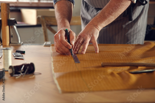 Man working with piece of leather in workshop, closeup