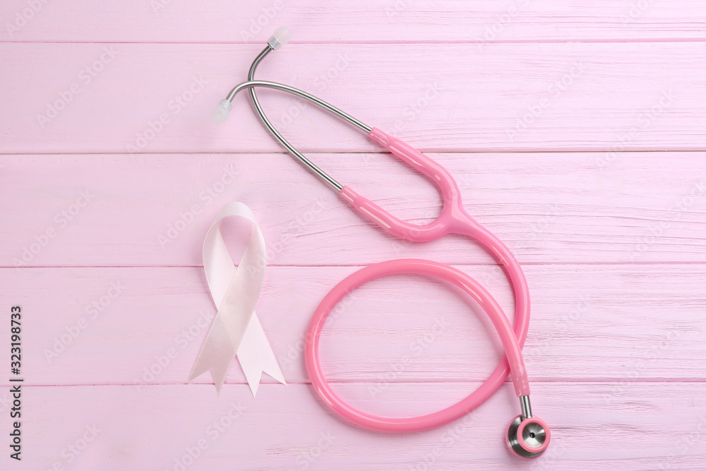 Pink ribbon and stethoscope on wooden background, flat lay. Breast cancer concept Pink ribbon and stethoscope on wooden background, flat lay. Breast cancer concept
