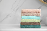Stack of fresh towels on white countertop in bathroom. Space for text