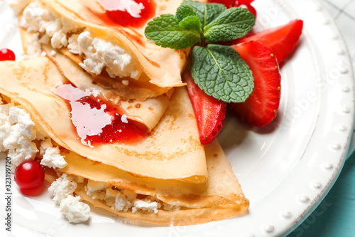 Delicious thin pancakes with cottage cheese and jam on plate, closeup