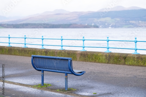 Lonely empty bench in open esplanade tranquil space on Scottish west coast town in Greenock photo