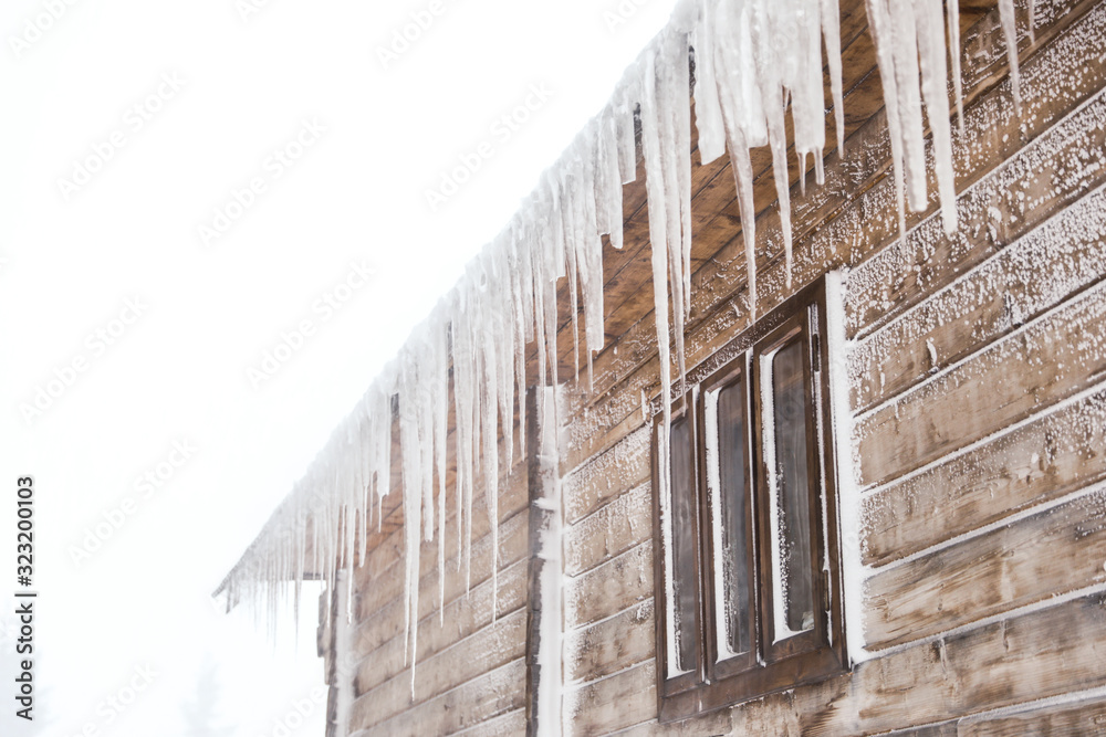 Wooden house with icicles on snowy day. Winter vacation Wooden house with icicles on snowy day. Winter vacation