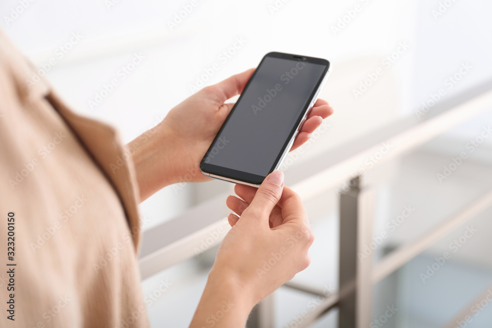 Young woman using modern smartphone indoors, closeup Young woman using modern smartphone indoors, closeup