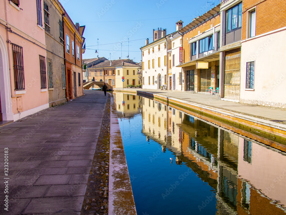 Un canale e i riflessi degli edifici sull'acqua a Comacchio, Emilia Romagna, Italia