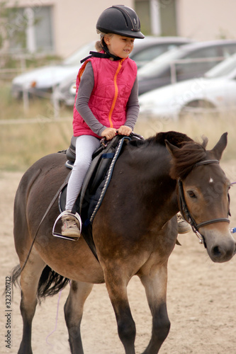 young girl learns to ride a horse © aRTI01