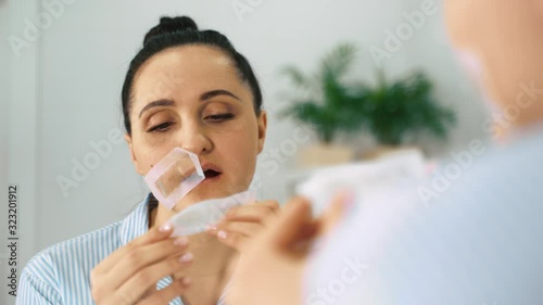 Close up. Woman removing mustache. a woman removes her mustache with wax strips. 