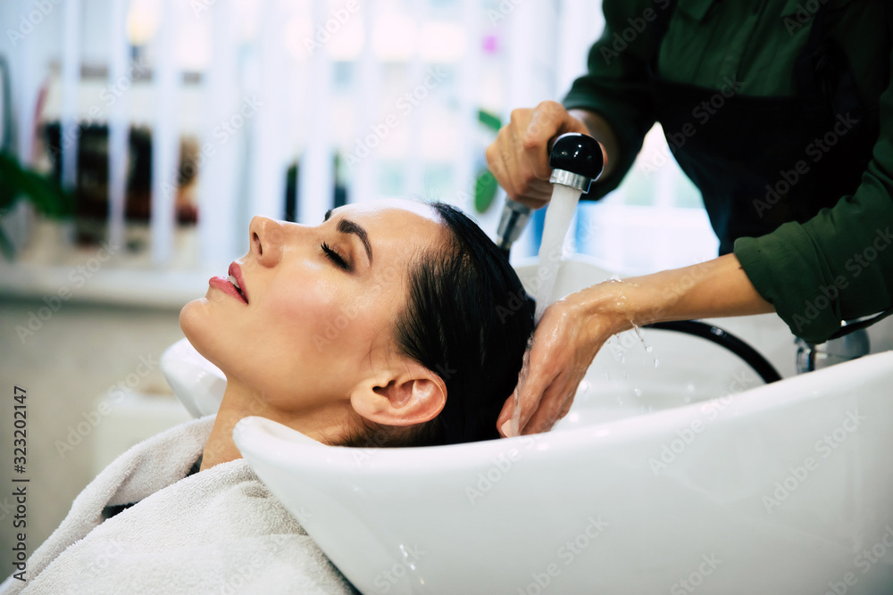 Over the moon. Portrait of a beautiful lady getting her hair washed in a salon by a young female hairstylist.