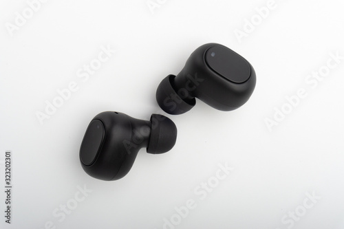 Wireless earbuds or earphones on white background. Copy space and technology concept