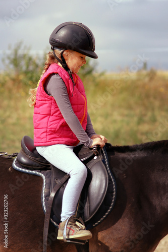 young girl learns to ride a horse