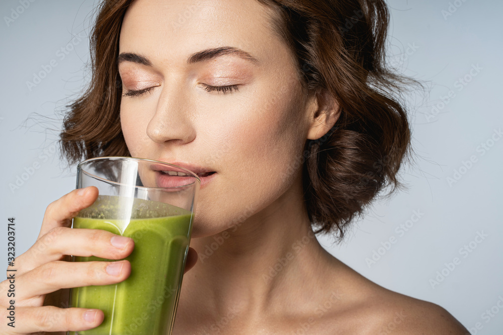 Relaxed brunette female person drinking green smoothie Relaxed brunette female person drinking green smoothie