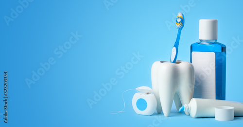 Set for cleaning teeth and mouth. Toothpaste, toothbrush, dental floss and mouthwash on a blue background. Copy space for text
