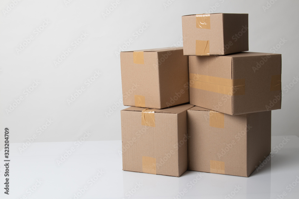 Fototapeta premium Pile of various size taped up cardboard boxes