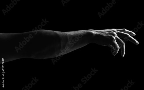 Detail of muscular man arm against a black background