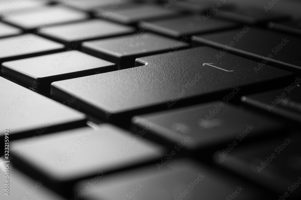 Laptop keyboard closeup in monochrome with selective focus on the 'Enter' key