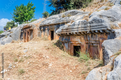 Ancient cemetery in the city of Limyra, Turkey. The entrance to the old concrete tomb in the rock. Excursion to the historical monument of architecture. Burial of ancestors closer to the sky photo