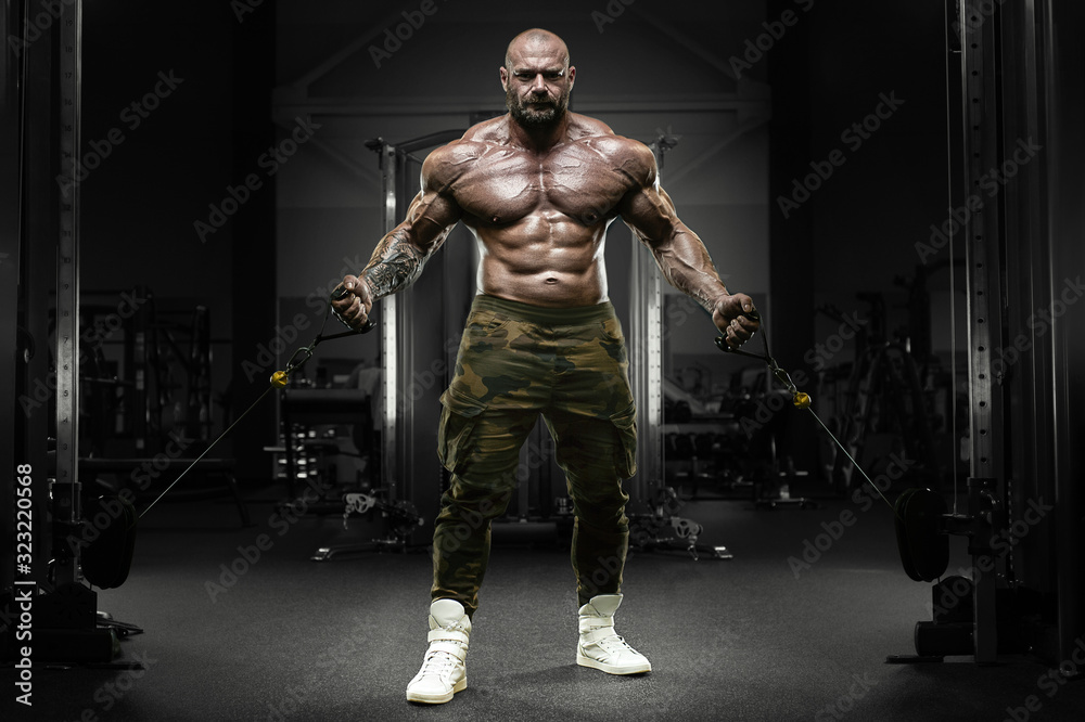 Bodybuilder strong athletic man pumping up muscles Bodybuilder strong athletic man pumping up muscles