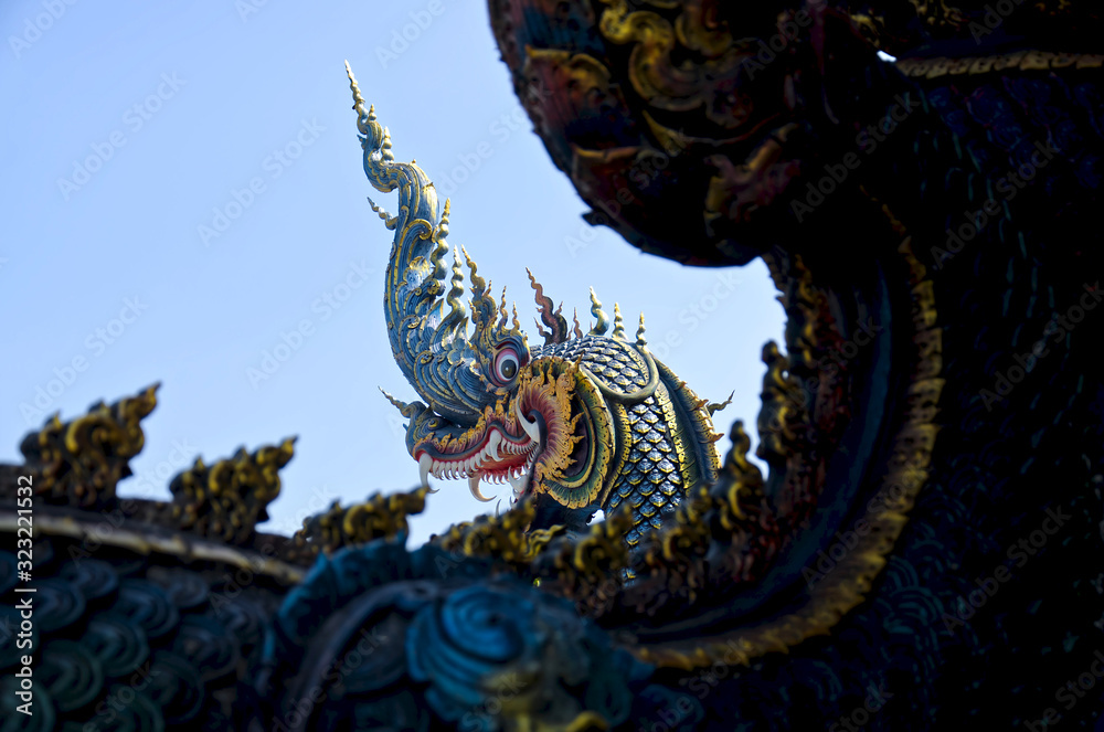 Beautiful blue naga sculpture (Thai dragon) on the blue sky background. Unique Blue Temple (Wat Rong Suea Ten)