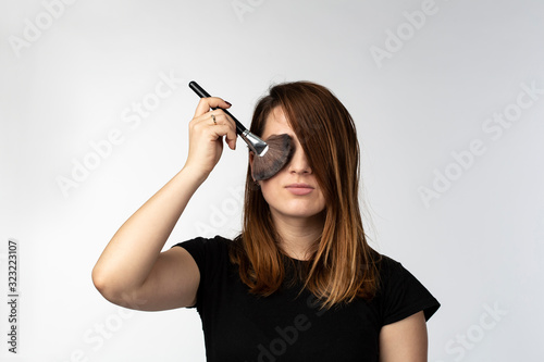 Woman holding make up brush © ShutterDivision