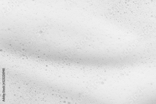 White cleanser foam texture background. Soap, shampoo bubbles closeup. Foamy skin care product sample photo