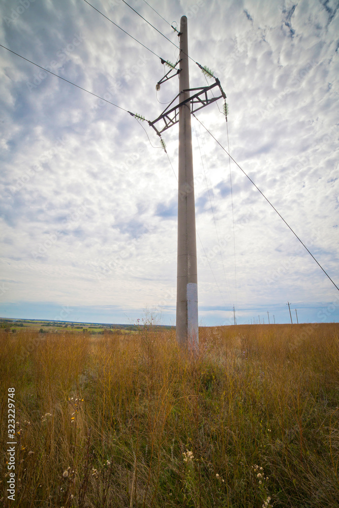 summer landscape with large meadows and blue sky, with electric transmission line